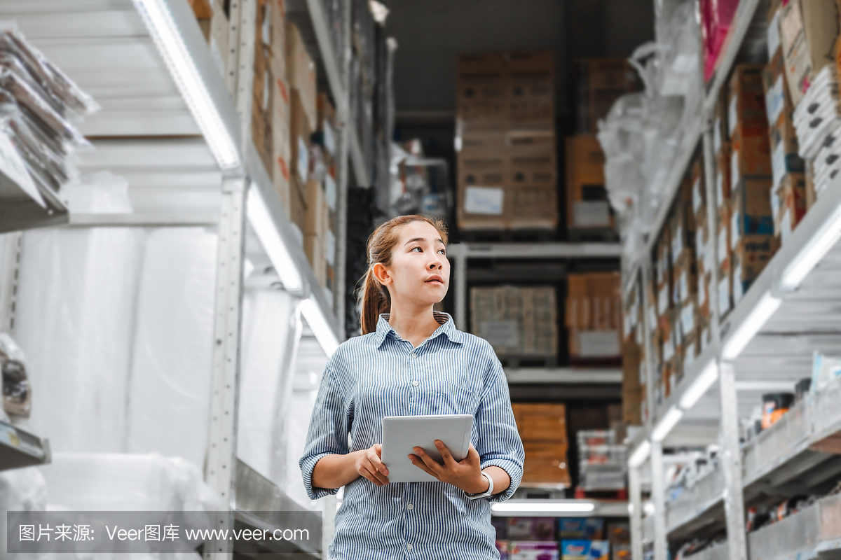 亚洲妇女工作与数字平板检查盒子物流进出口物资包在仓库,物流概念